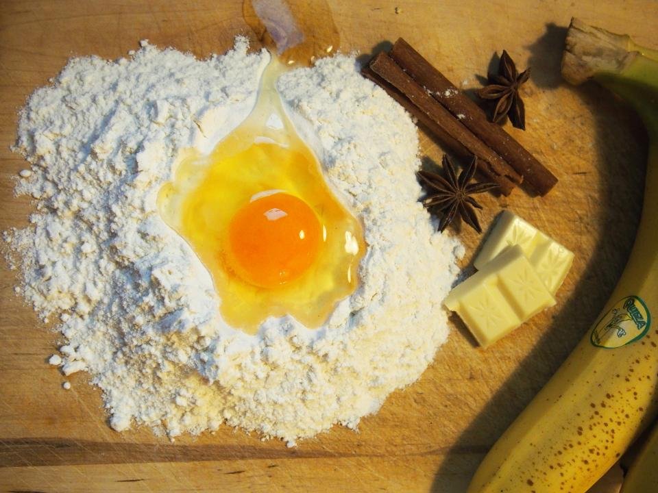 Flour with an egg yolk and baking ingredients on a table