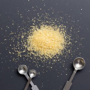 Golden granulated sugar with measuring spoons