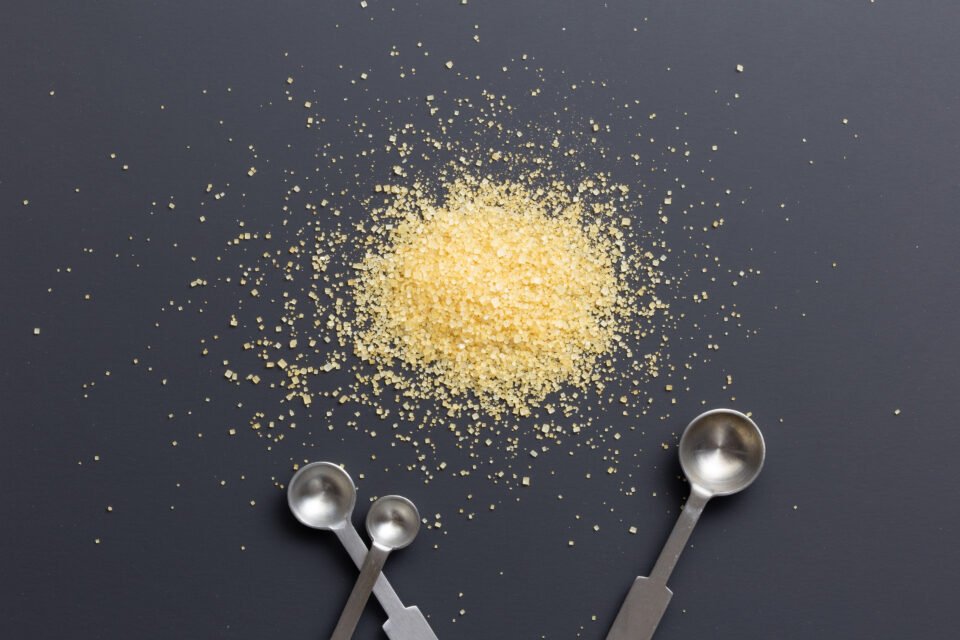 Golden granulated sugar with measuring spoons