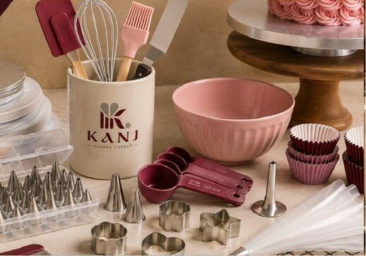 KANJ baking tools display with whisk, spatulas, pink mixing bowl, piping nozzles and cutters